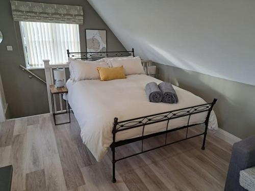 - une chambre avec un grand lit et des oreillers dans l'établissement Suffolk View Apartment, à Tuddenham