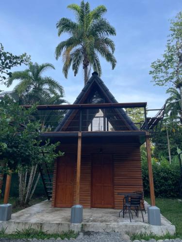una piccola cabina con una palma sullo sfondo di Bungalows Sloth a Manzanillo