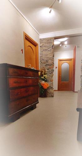 a living room with a dresser and a stone wall at Ristorante Bellavista con Locanda in Veleso
