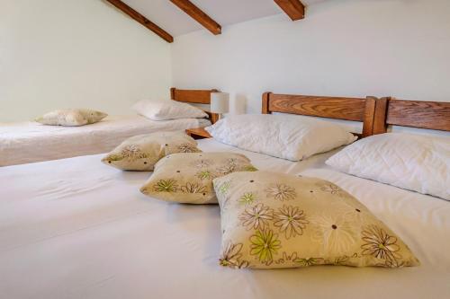 a room with three beds with pillows on them at Apartments & rooms Lucie in Posedarje
