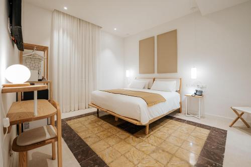 a white bedroom with a bed and a table at Emblemático F24-Only Adults B&B in Santa Cruz de Tenerife
