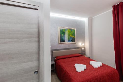 a bedroom with a red bed with two white chairs on it at Affittacamere Alessia in Sanremo
