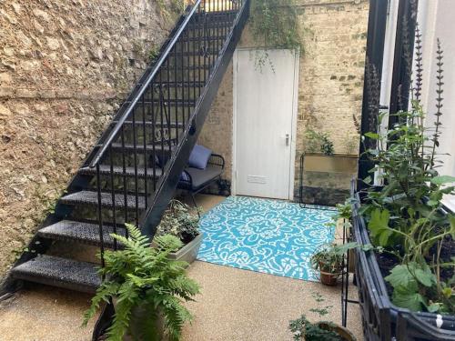 un escalier menant à une porte blanche avec un sol bleu dans l'établissement Cosy Courtyard Apartment in Kemptown, à Brighton et Hove