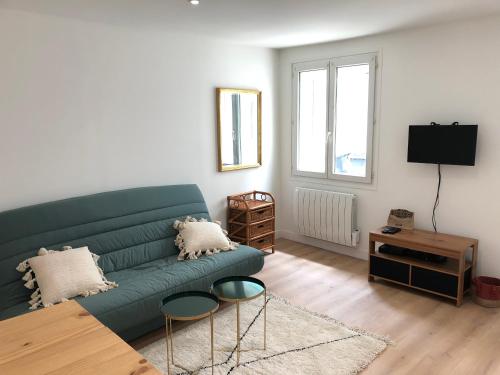 sala de estar con sofá verde y mesa en BLUE Studio cosy et calme proche du centre avec TV et Wifi, en La Rochelle