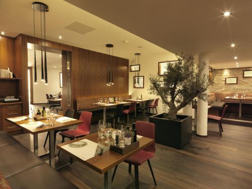 a dining room with tables and chairs in a restaurant at Apart Holidays in Morschach