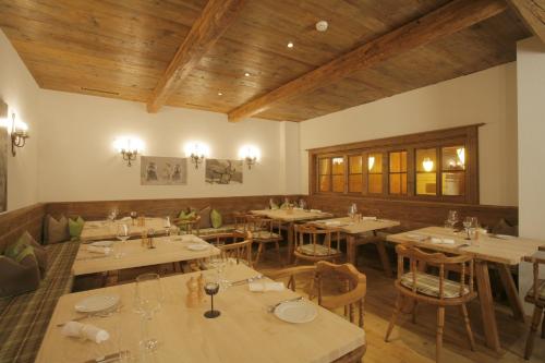 a restaurant with tables and chairs and wooden ceilings at Apart Holidays in Morschach