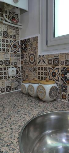 a bathroom with a sink and tiles on the wall at Cosy house in Alger
