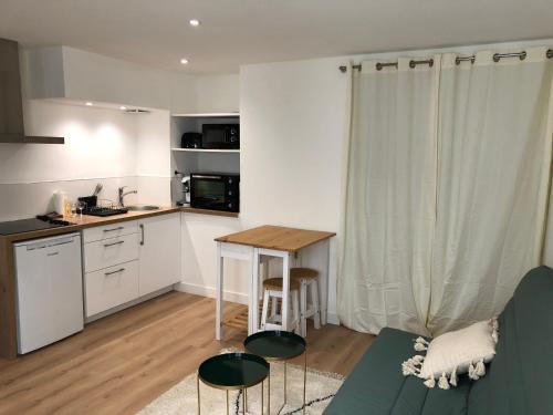 Il dispose d'une cuisine et d'un salon avec une table et un canapé. dans l'établissement BLUE Studio cosy et calme proche du centre avec TV et Wifi, à La Rochelle