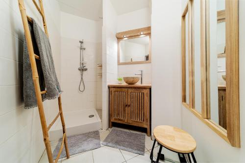 a bathroom with a wooden stool and a sink and a tub at Ti case a moin - Joli T2 en bord de mer in Saint-Pierre
