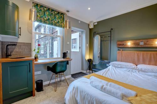 um quarto com uma cama, uma secretária e uma janela em The Old Laundry eco annex w free parking em Norwich