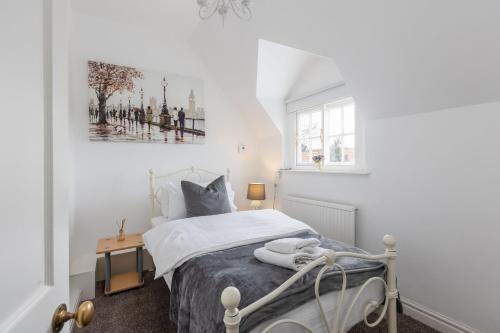 a white bedroom with a bed and a window at Quaint Cottage in the heart of North Yorkshire Village - Pet Friendly FREE in Stillington