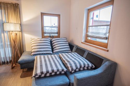 a couch with two pillows on it in a room at Hirsch Chalet #Sauna in Lechbruck
