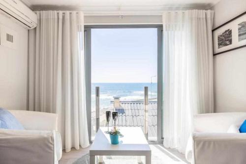 - un salon avec une grande fenêtre donnant sur l'océan dans l'établissement Vista Mare Beach Apartments by Destiny Houses, à Cortegaça