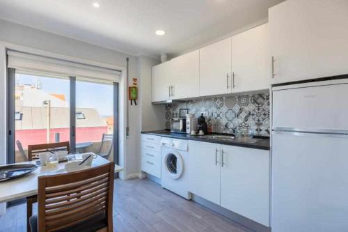 a kitchen with white cabinets and a white refrigerator at Vista Mare Beach Apartments by Porto City Hosts in Cortegaça