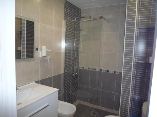 a bathroom with a shower and a toilet and a sink at Apartamentos 2 Las Americas in Playa de las Americas