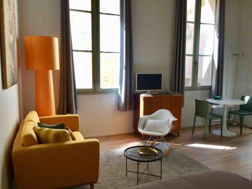 salon z żółtą kanapą i stołem w obiekcie Studio Anna centre historique Bordeaux St Pierre w mieście Bordeaux