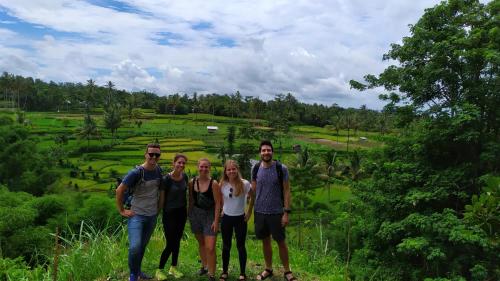 a group of people standing in front of a field at Novia Guest House Lombok-Tetebatu in Tetebatu