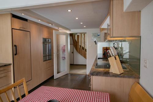 a kitchen with wooden cabinets and a red table at Cosy Family House in Alt Sankt Johann