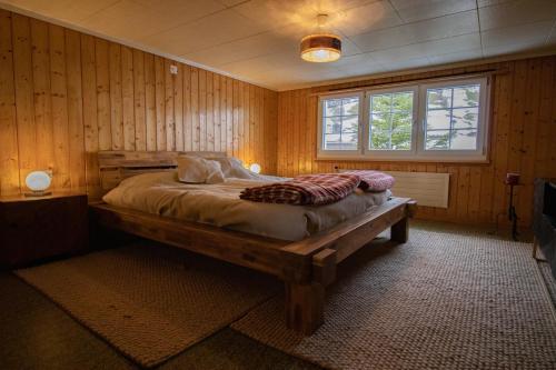 a bedroom with a bed in a room with wooden walls at Cosy Family House in Alt Sankt Johann