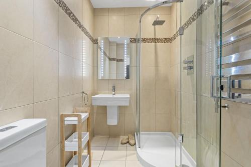 a bathroom with a shower and a sink and a tub at 14 At The Beach, Torcross in Beesands