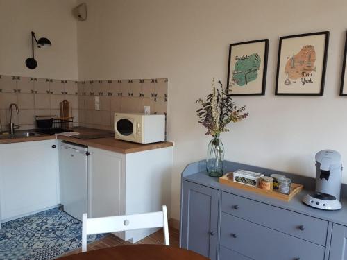 a kitchen with a counter and a table with a vase of flowers at LE PETIT MATELOT in Honfleur