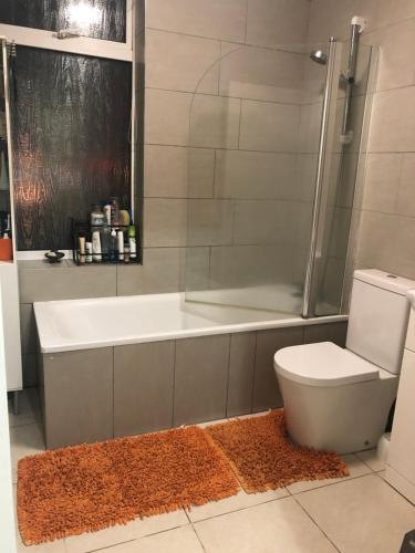 La salle de bains est pourvue d'une baignoire, de toilettes et d'une douche. dans l'établissement Rosie Cosy House Cricklewood, à Londres