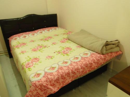 a small bed with a flowery blanket on it at Sky IZMIR Center Big Suit Home in İzmir