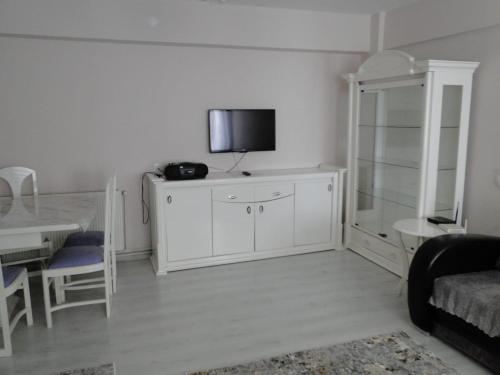 a living room with a tv on a white wall at Sky IZMIR Center Big Suit Home in İzmir
