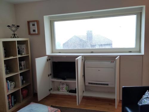 a living room with a large window and a tv at Casa na Fraga in Aldeia das Dez
