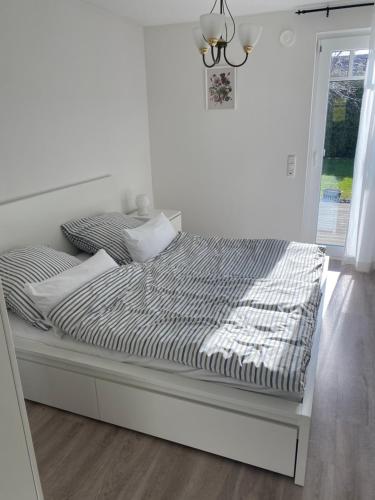 uma cama num quarto branco com uma janela em Rose Garden em Hessisch Oldendorf