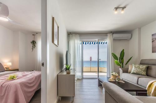 a living room with a bed and a view of the ocean at tuGuest Velilla Apartment in Almuñécar