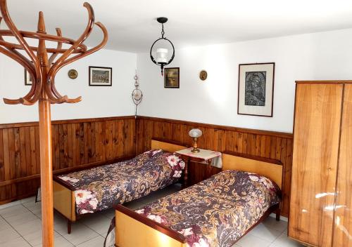 two beds in a room with wood paneling at Guest House - Heaven in Byala