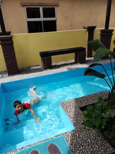 a young boy swimming in a swimming pool at Rumah Cikgu 3bilik tidur in Jitra