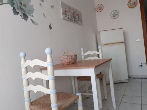 a table and chairs in a kitchen with a refrigerator at Residenza La Lanterna in Genoa