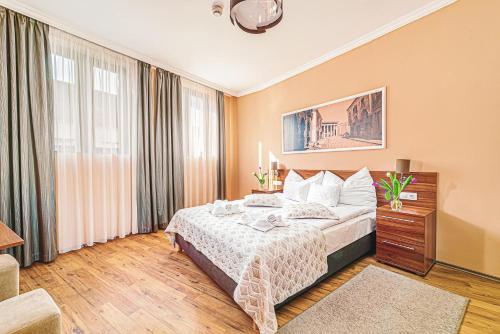 Cette chambre comprend un lit et une grande fenêtre. dans l'établissement Forum Hotel, à Szombathely