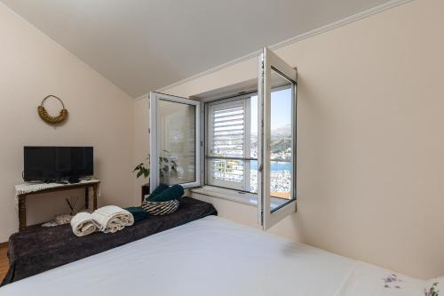 um quarto com uma cama e uma grande janela em Denise em Dubrovnik