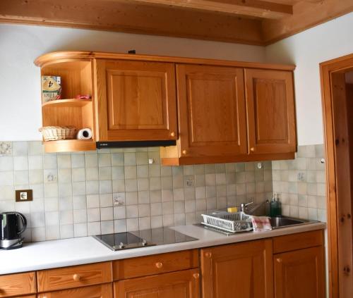 una cocina con armarios de madera y fregadero en Apartement Noggler, en Malles Venosta