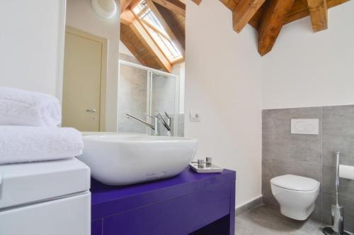La salle de bains est pourvue d'un lavabo blanc et de toilettes. dans l'établissement Villa Massari, à Milan