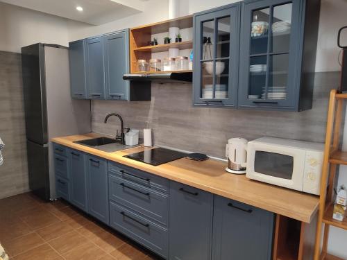 a kitchen with blue cabinets and a microwave at Połoninka in Ustrzyki Górne