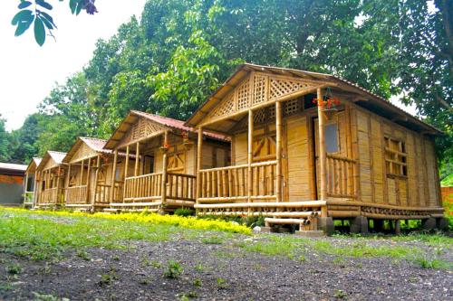 Une rangée de maisons en bois sont bordées dans l'établissement Cabañas Los Pomarrosos, à Utica