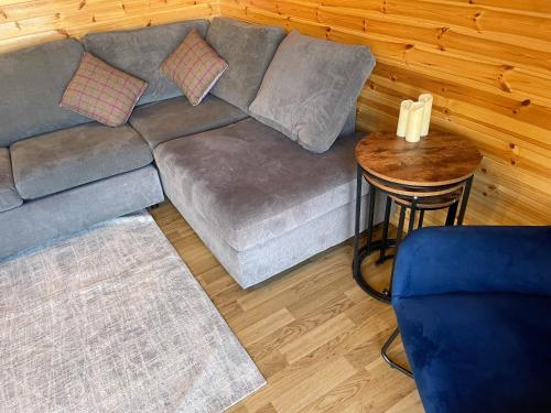 a living room with a couch and a table at Hedgehog's Nest in Bathgate