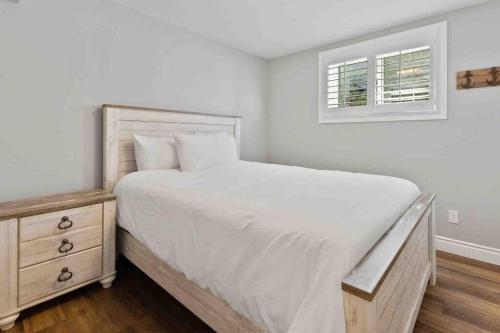 a white bedroom with a large bed and a window at Impressive Modern Waterfront Home on Georgian Bay in Port McNicoll