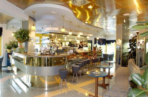 bar w restauracji z krzesłami i ladą w obiekcie Hotel Luna w Bibione