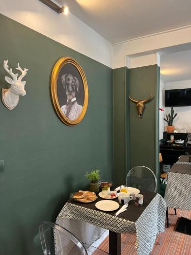 a dining room with a table and a picture of a dog on the wall at The Originals Boutique, Hôtel d'Angleterre, Le Havre, centre, plage in Le Havre
