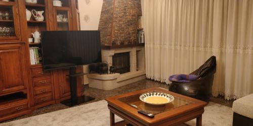a living room with a television and a fireplace at Casa Barranqueiro in Vilaboa