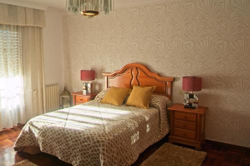 a bedroom with a bed with two night stands and two lamps at Casa Barranqueiro in Vilaboa