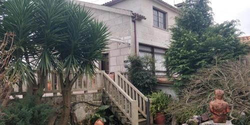 a house with a staircase in front of a building at Casa Barranqueiro in Vilaboa