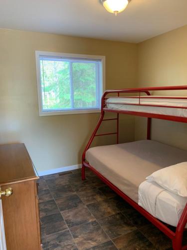 a bedroom with two bunk beds and a window at Wu Wu's Cabins in Wasaga Beach