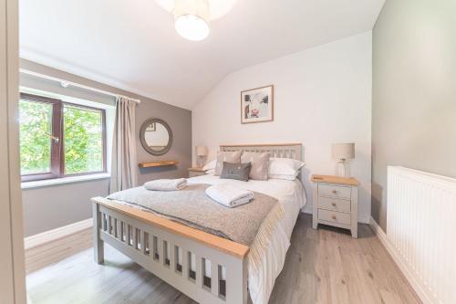 um quarto com uma cama e uma janela em Cow Barn, Duddon Bridge em Broughton in Furness