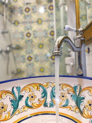 a bathroom sink with water coming from a faucet at Milton Boutique Hotel - Adults Only in Lido di Jesolo